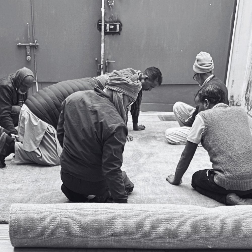 Master weavers inspect a finished handwoven rug for quality, finish and consistency before dispatch from the House of Bohi workshop in Bhadohi, India.