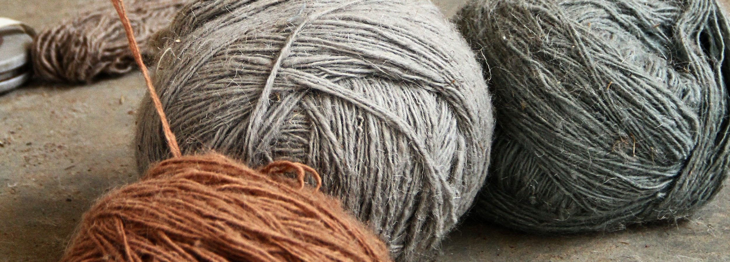 Hand-spun natural fibre yarn in soft grey and earthy terracotta tones at the House of Bohi workshop in Bhadohi, India, where every handwoven rug begins.