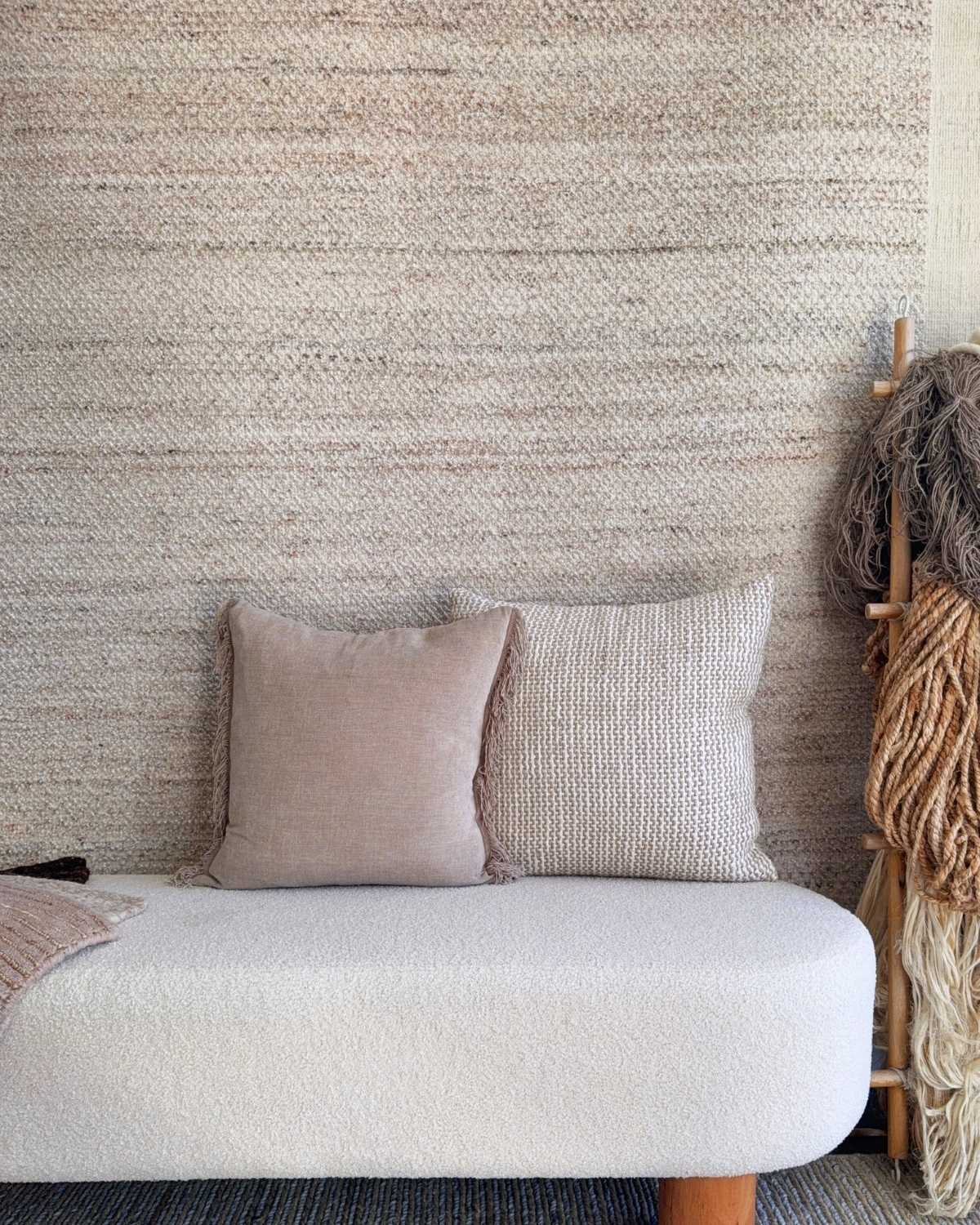 Akira hand-knotted undyed wool rug in Dune, styled in a neutral living room with soft beige and brown tones for a warm, naturally textured interior.