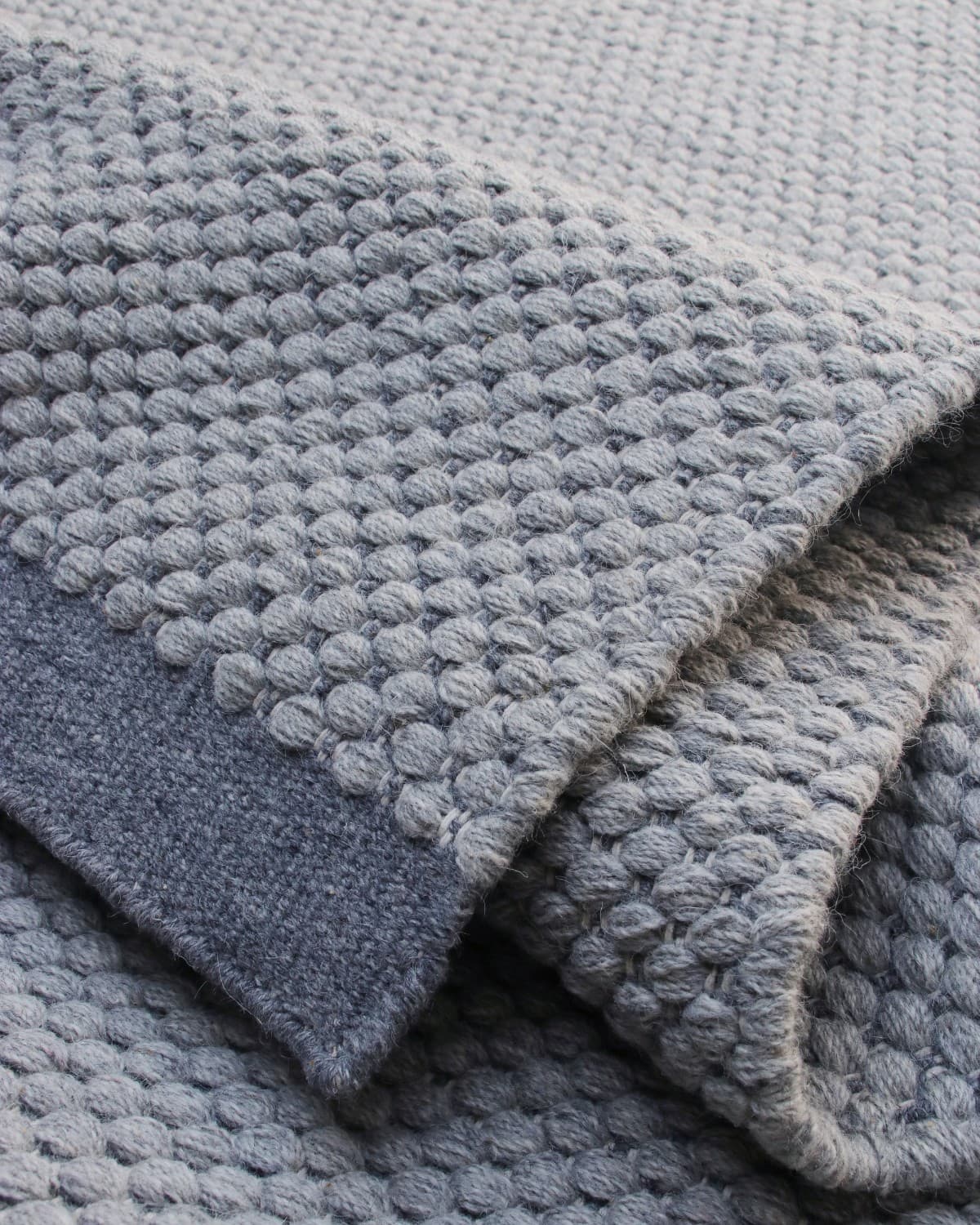 Folded border detailing the transition from a beaded wool center to a seamless flatweave edge for a modern study.