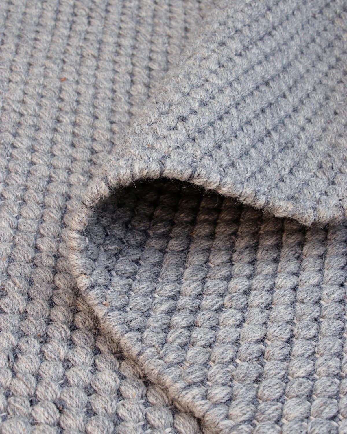Folded drape showcasing the soft texture and flexible nature of premium New Zealand wool in a low 12mm pile height.