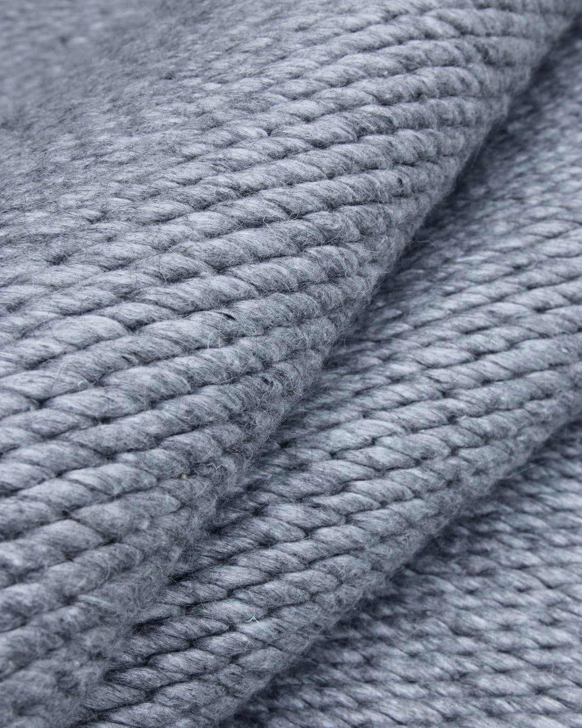 Folded drape emphasizing the substantial 5000gsm profile and flexible construction of the premium New Zealand wool.