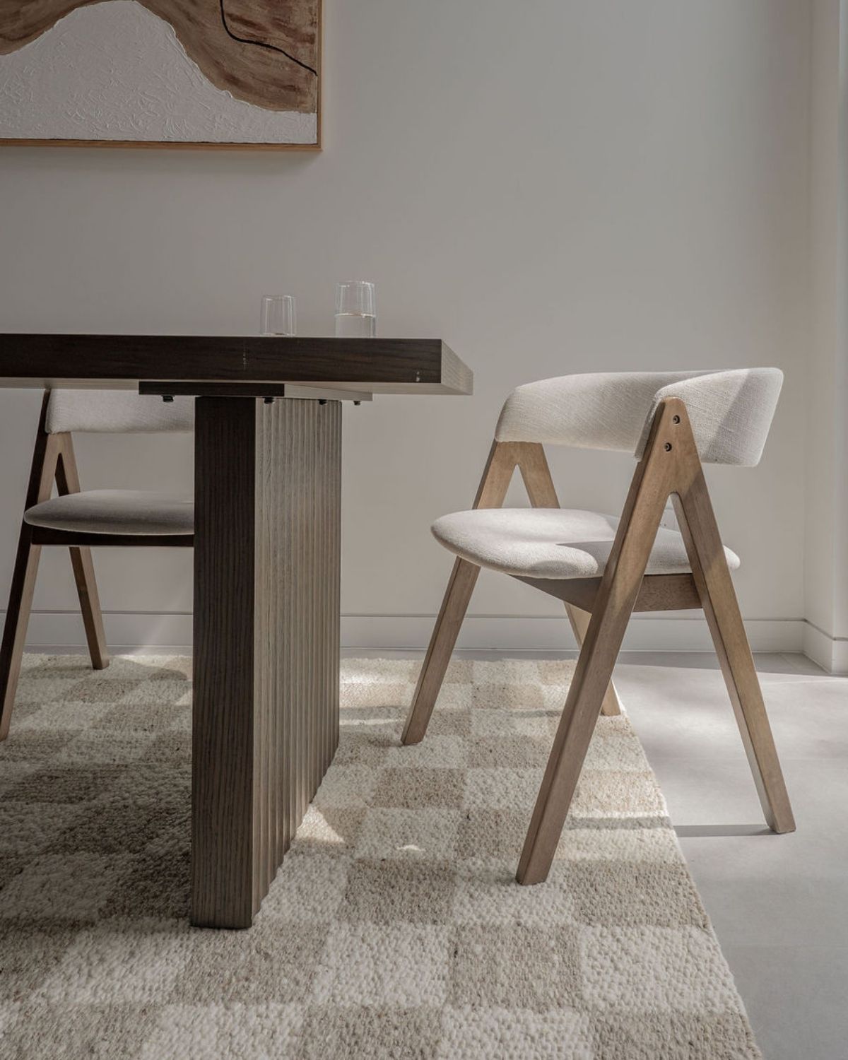 Cora undyed wool rug by House of Bohi, styled beneath a timber dining table and upholstered chairs in a contemporary Sydney interior, featuring a plush handwoven flatweave in natural ivory and warm beige tones with a subtle geometric pattern.