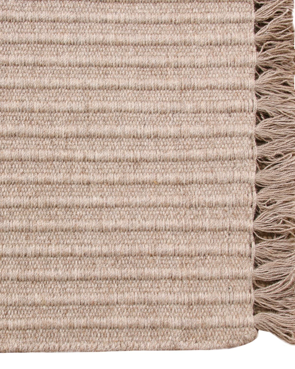 Playful fringe edge of a brown wool runner, ethically handmade in Bhadohi, India and GoodWeave certified for an entryway.