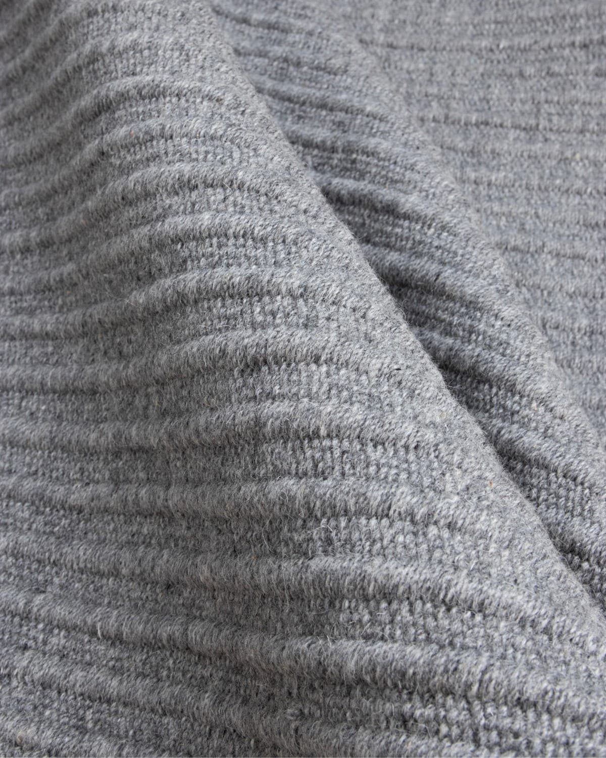 Folded reversible flatweave revealing subtle tactile relief and a 12mm pile height, ideal for a structured hallway.
