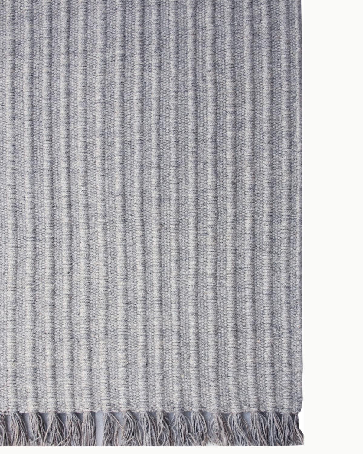 Detailed look at the playful fringe edge of this structured wool flatweave, fully GoodWeave certified.