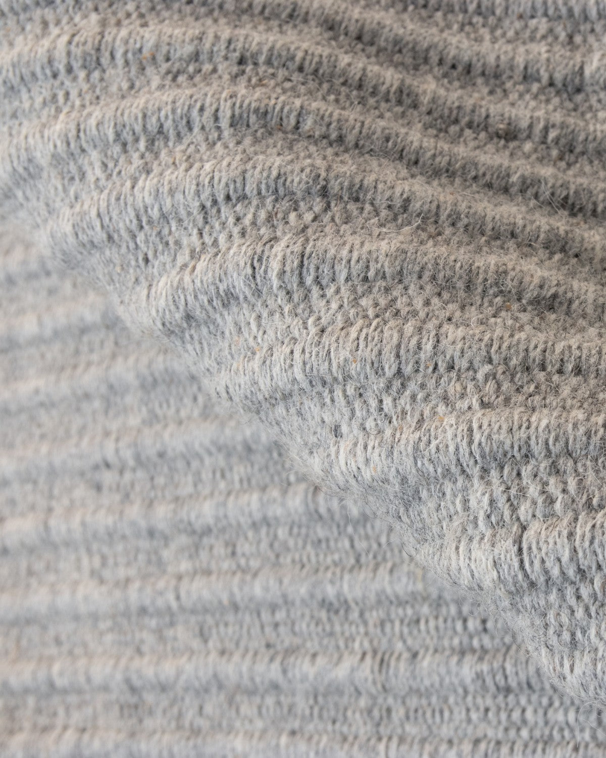 Folded reversible flatweave showing subtle tactile relief and a 12mm pile height, ideal for a structured hallway.