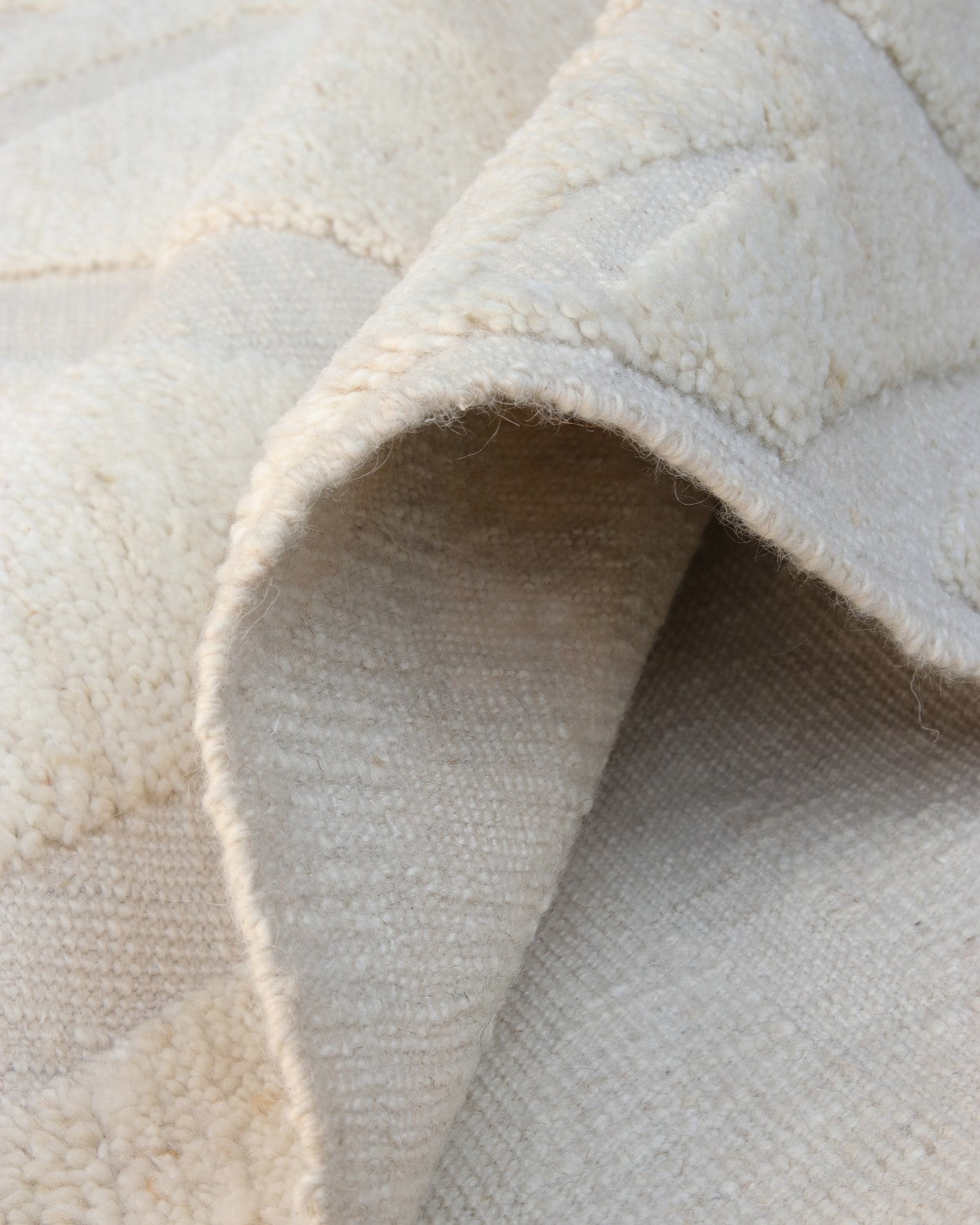 Folded corner revealing a plush cut-pile set against a flatter base, bringing quiet luxury to a living room or bedroom.