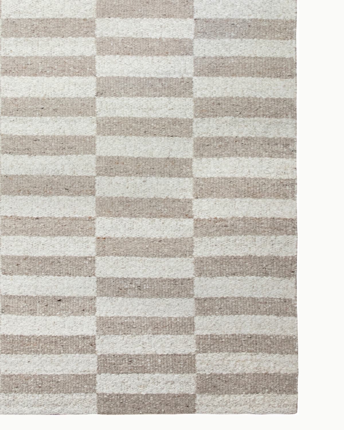 Undyed New Zealand wool showcases organic tonal variations in this handwoven flatweave, perfect for an earthy living room.