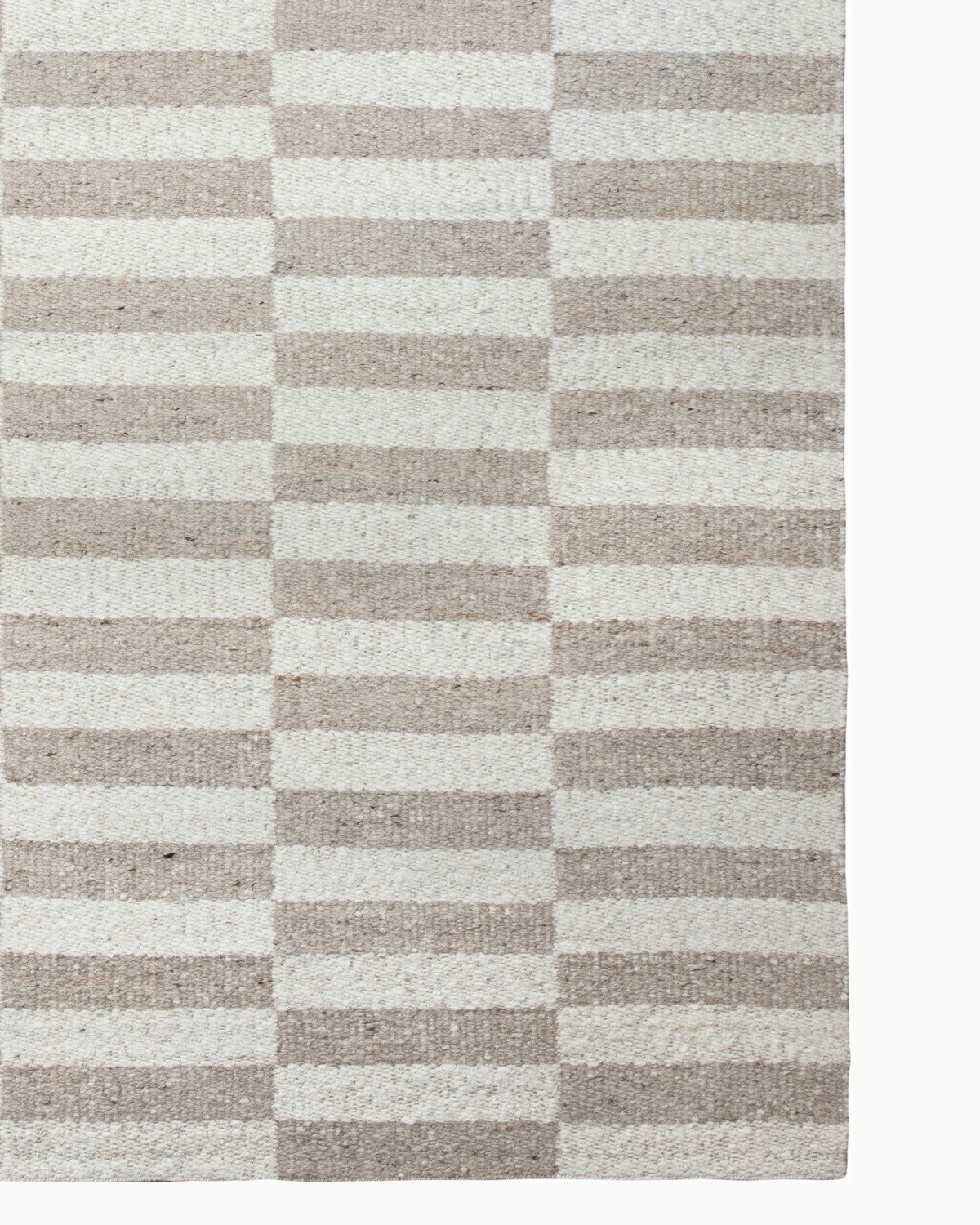 Undyed New Zealand wool showcases organic tonal variations in this handwoven flatweave, perfect for an earthy living room.
