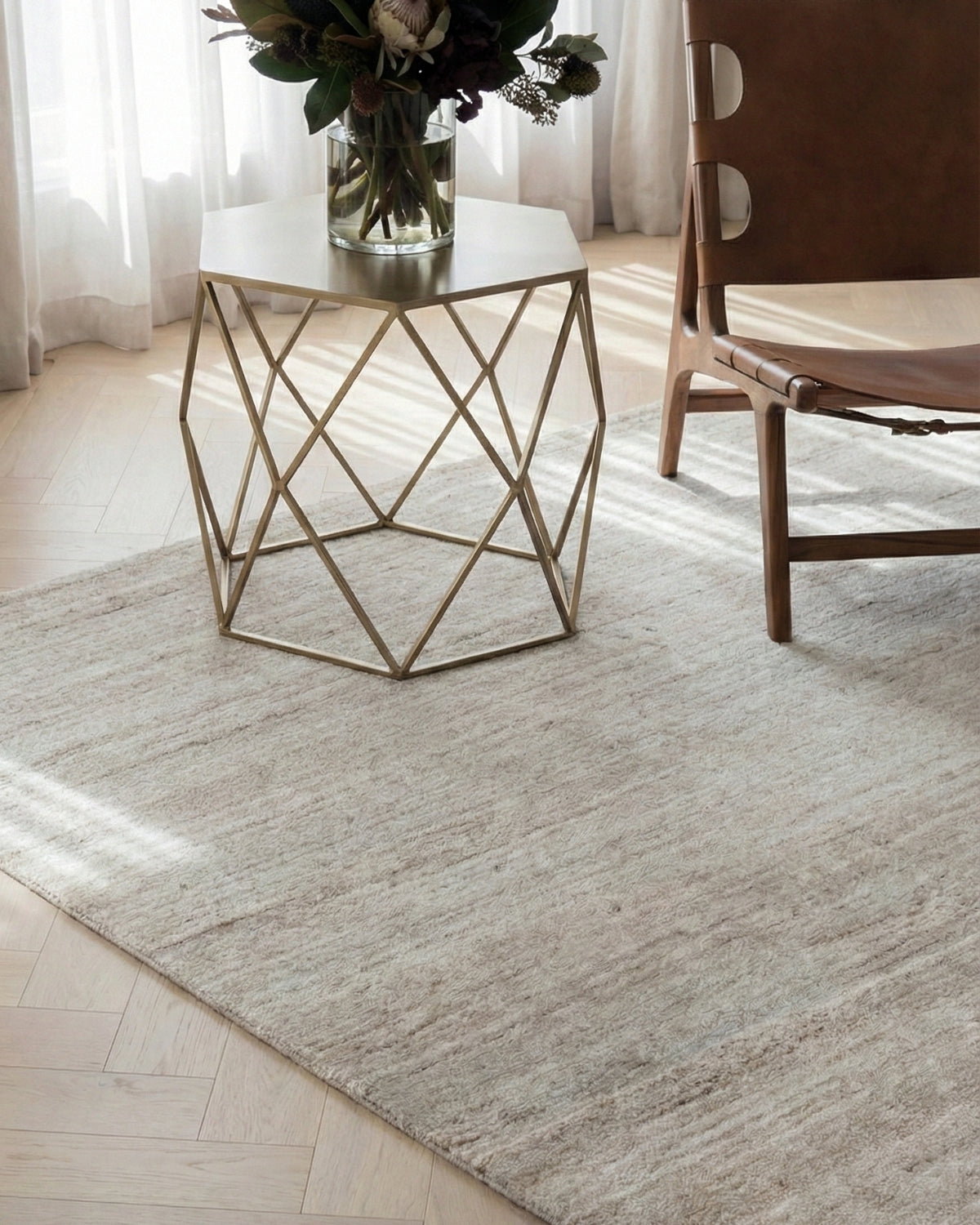 Handloomed beige rug with a silky, velvety touch and subtle horizontal striations styled in a quiet luxury living space.