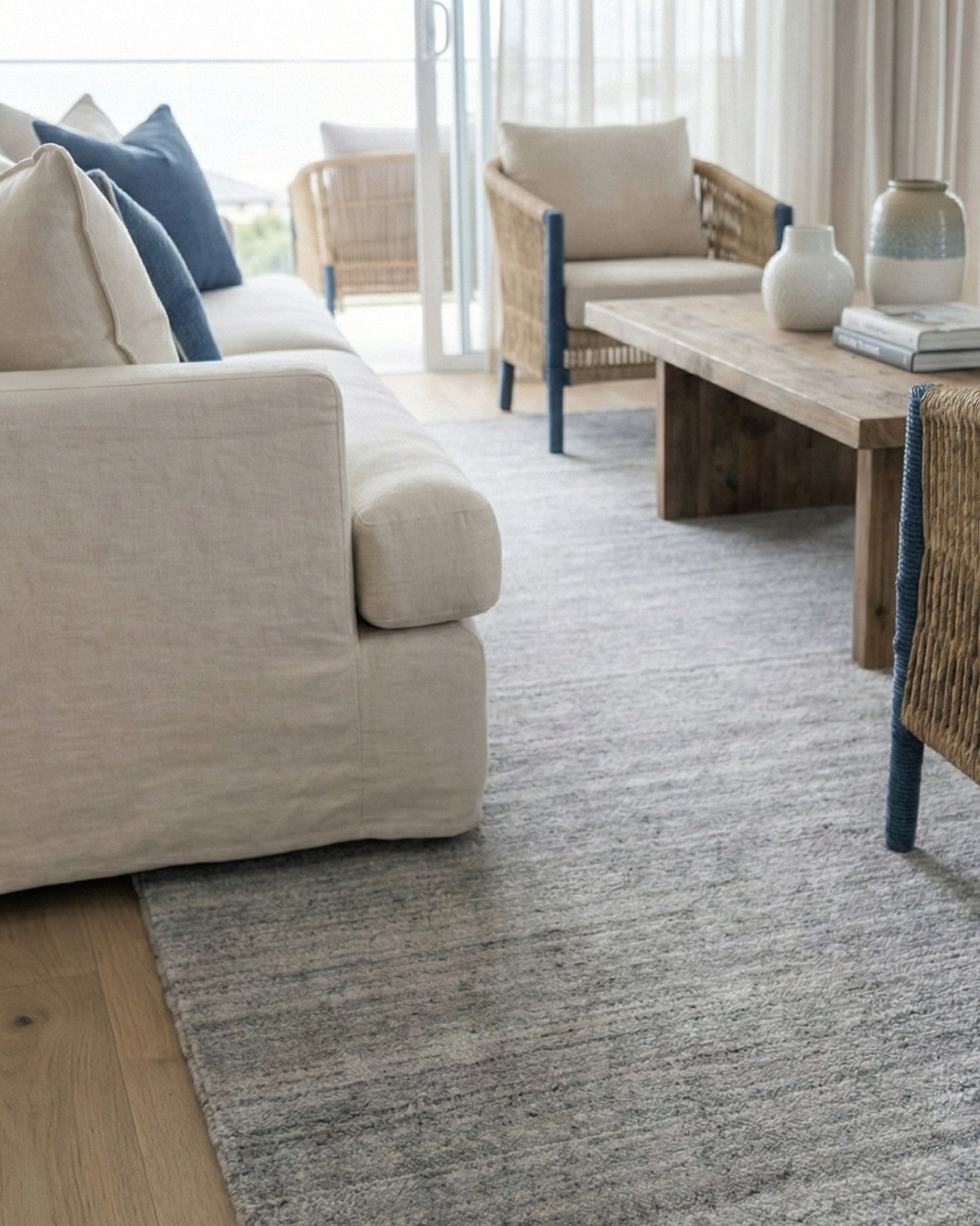 Handloomed silver grey rug with a silky, velvety touch and subtle horizontal striations styled in a quiet luxury living space.