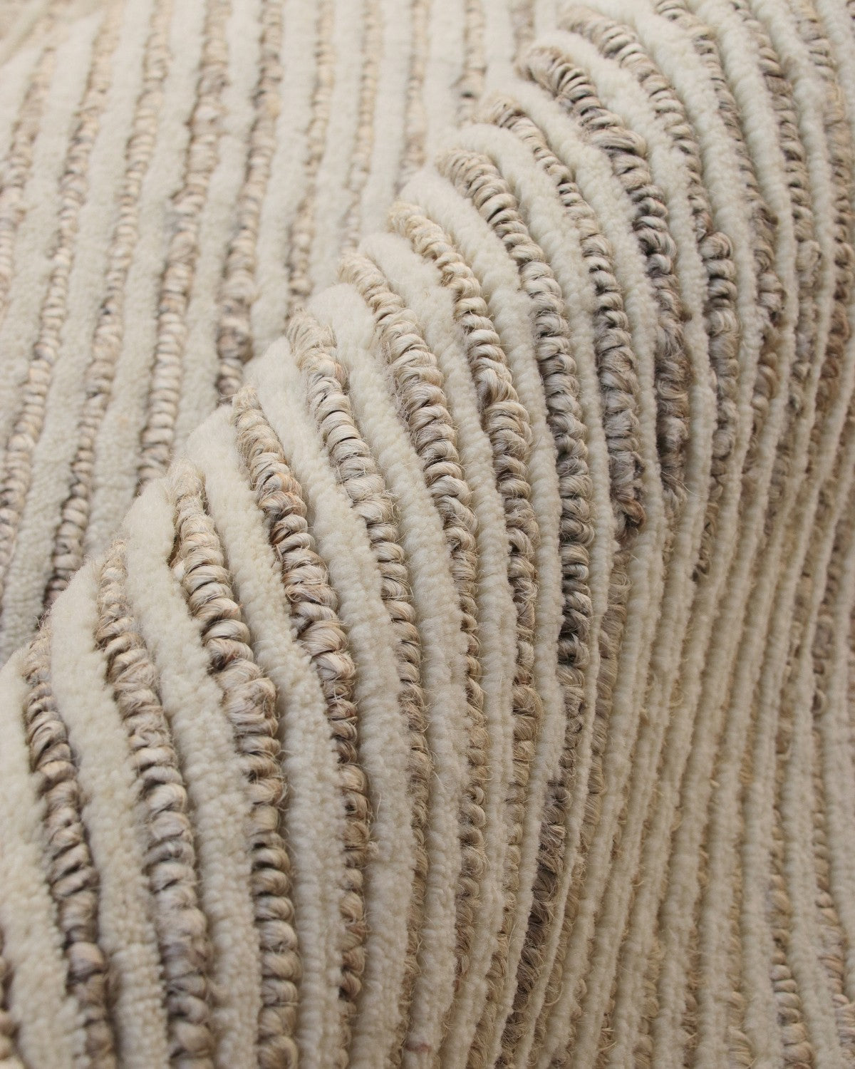 A macro look at the handknotted cut-and-loop texture, showcasing linear rows of plush wool and natural jute.