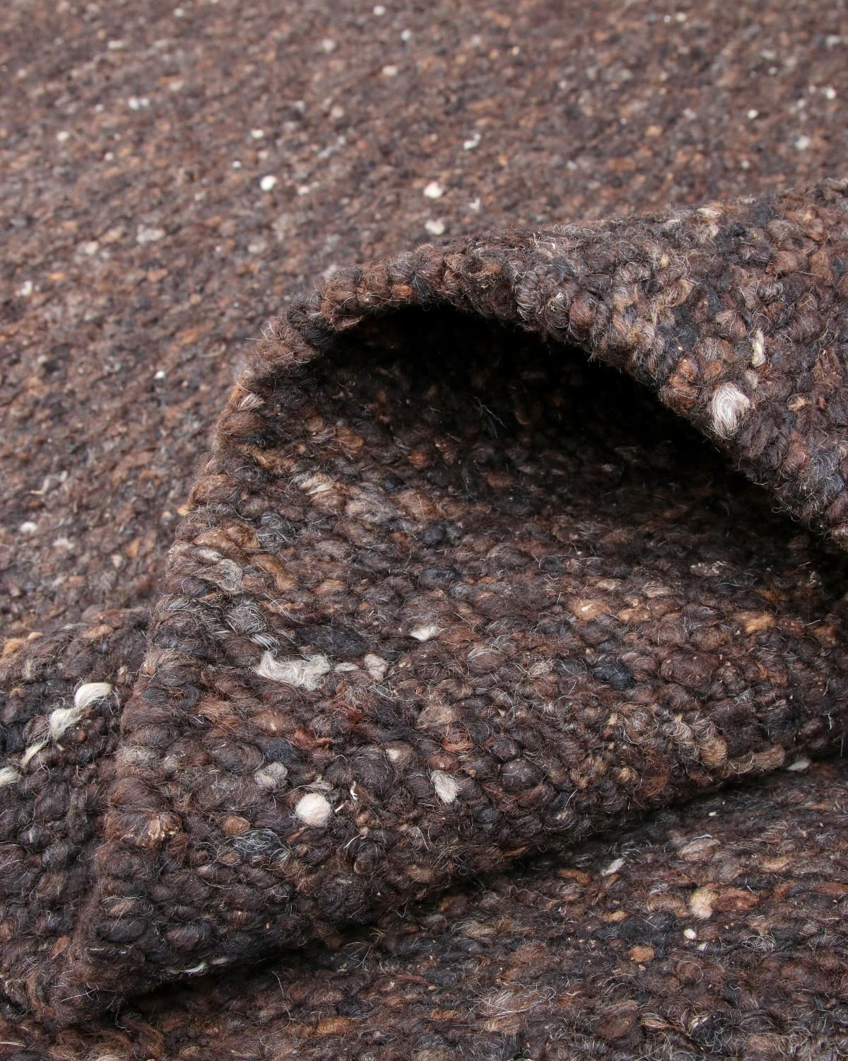 A soft corner drape highlights the resilient 12mm pile, ideal for bringing grounded warmth to a living room, dining room, or study.