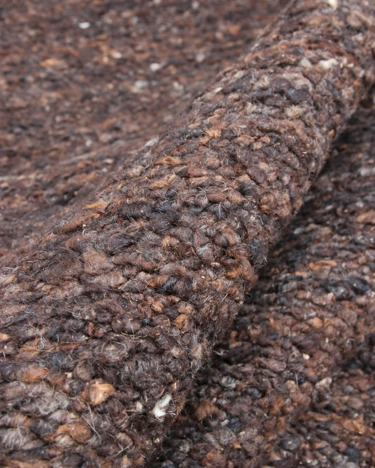 Close up of the hand-carded wool revealing organic tonal variations for a rustic and refined heathered surface.