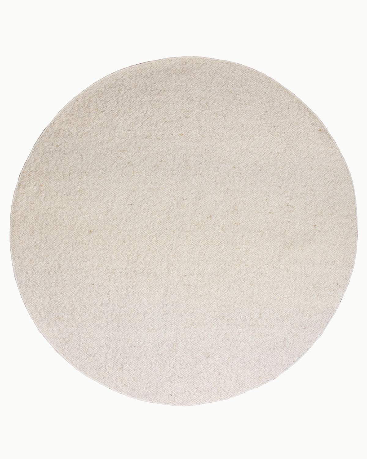 Overhead view of the circular variation, an ethically handmade, GoodWeave certified Indian floor piece providing grounded warmth for a bedroom or dining room.