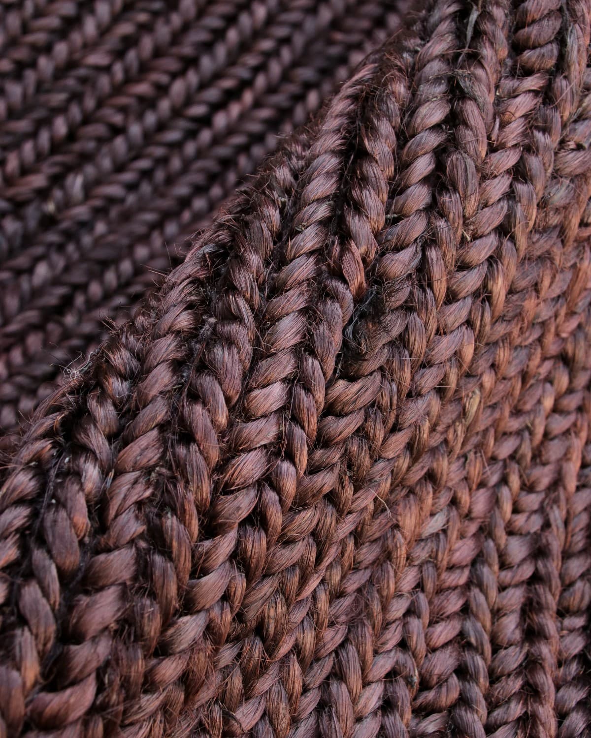 Extreme close up revealing the thick 12mm pile and natural earthy texture of the handwoven flatweave braided construction.