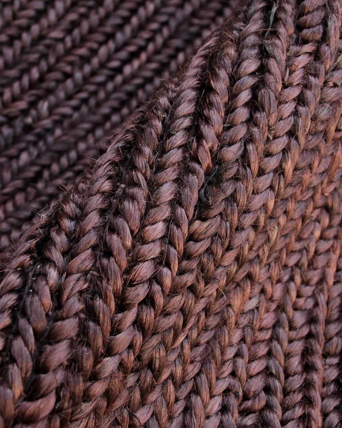 Extreme close up revealing the thick 12mm pile and natural earthy texture of the handwoven flatweave braided construction.