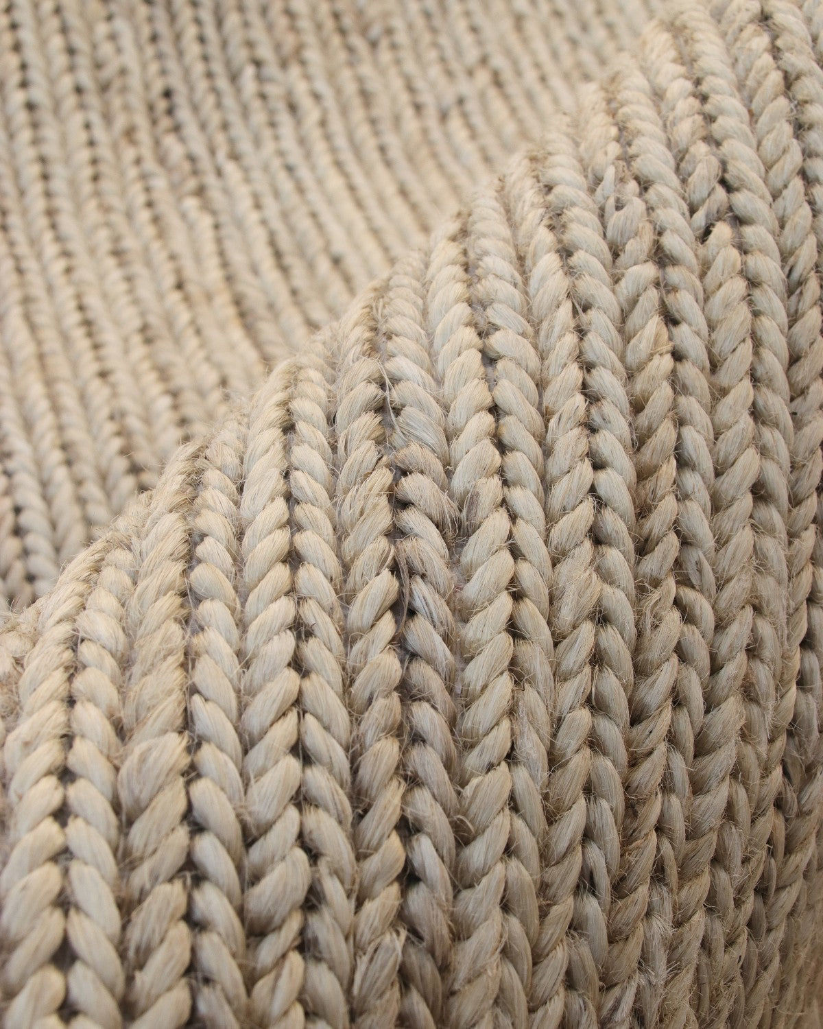 Extreme close up of the premium hand-harvested woven braids, highlighting the 12mm pile and relaxed, earthy texture.