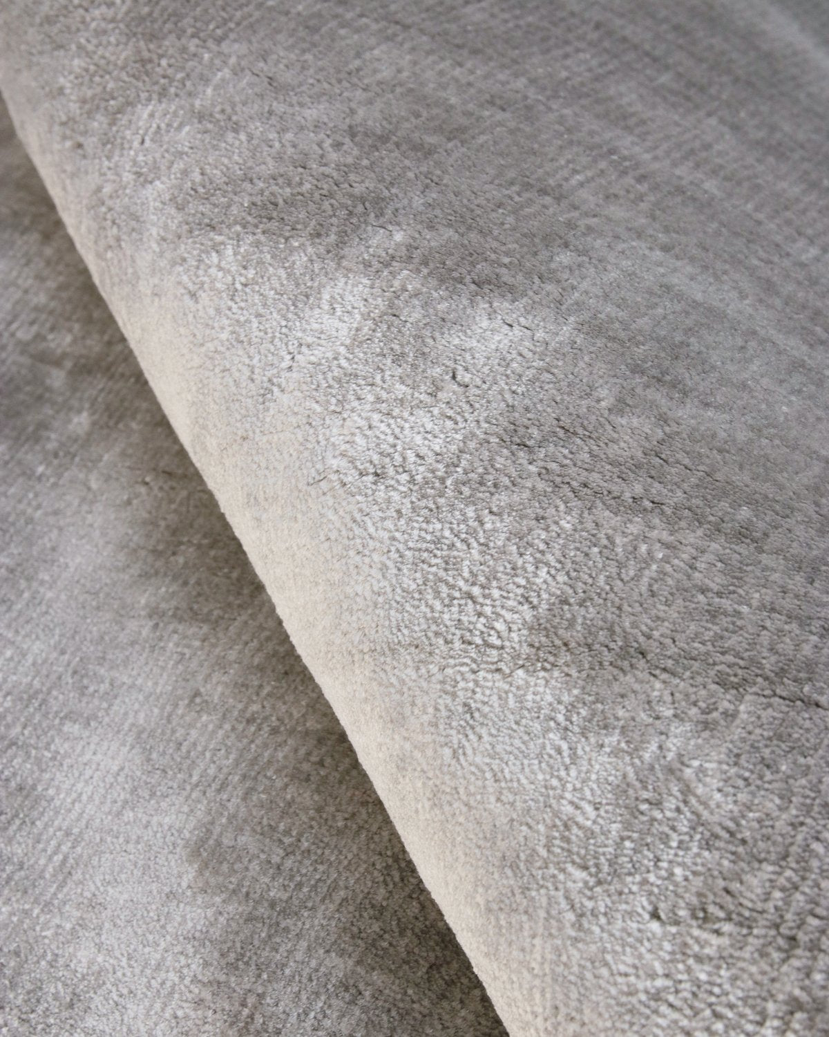Close up of a handloomed 12mm dense cut pile, showing shifting sheen and shadow in the natural fibres.
