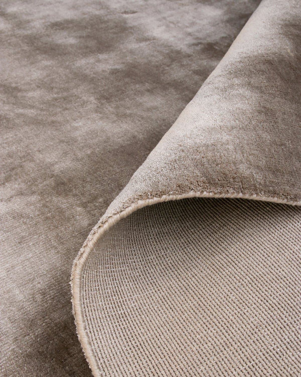 Folded corner revealing the secure edge binding and GoodWeave certified ethical construction from Bhadohi, India.