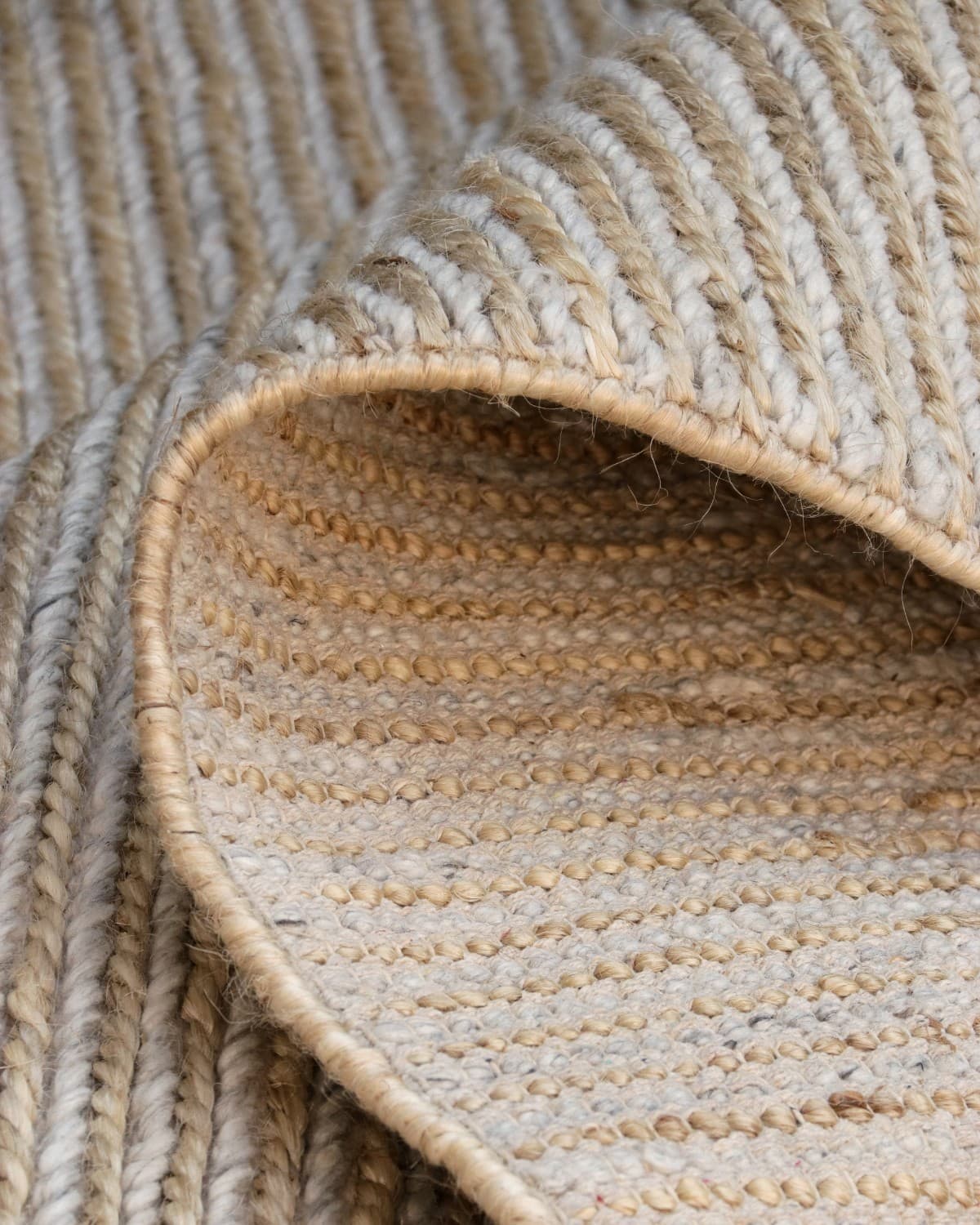 Folded corner revealing a durable 12mm handwoven flatweave construction. This resilient design is GoodWeave Certified.