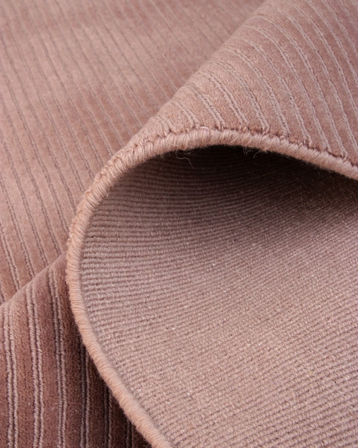 Folded mushroom floor covering showing crisp edge finishing. This GoodWeave certified piece is ideal for living rooms.