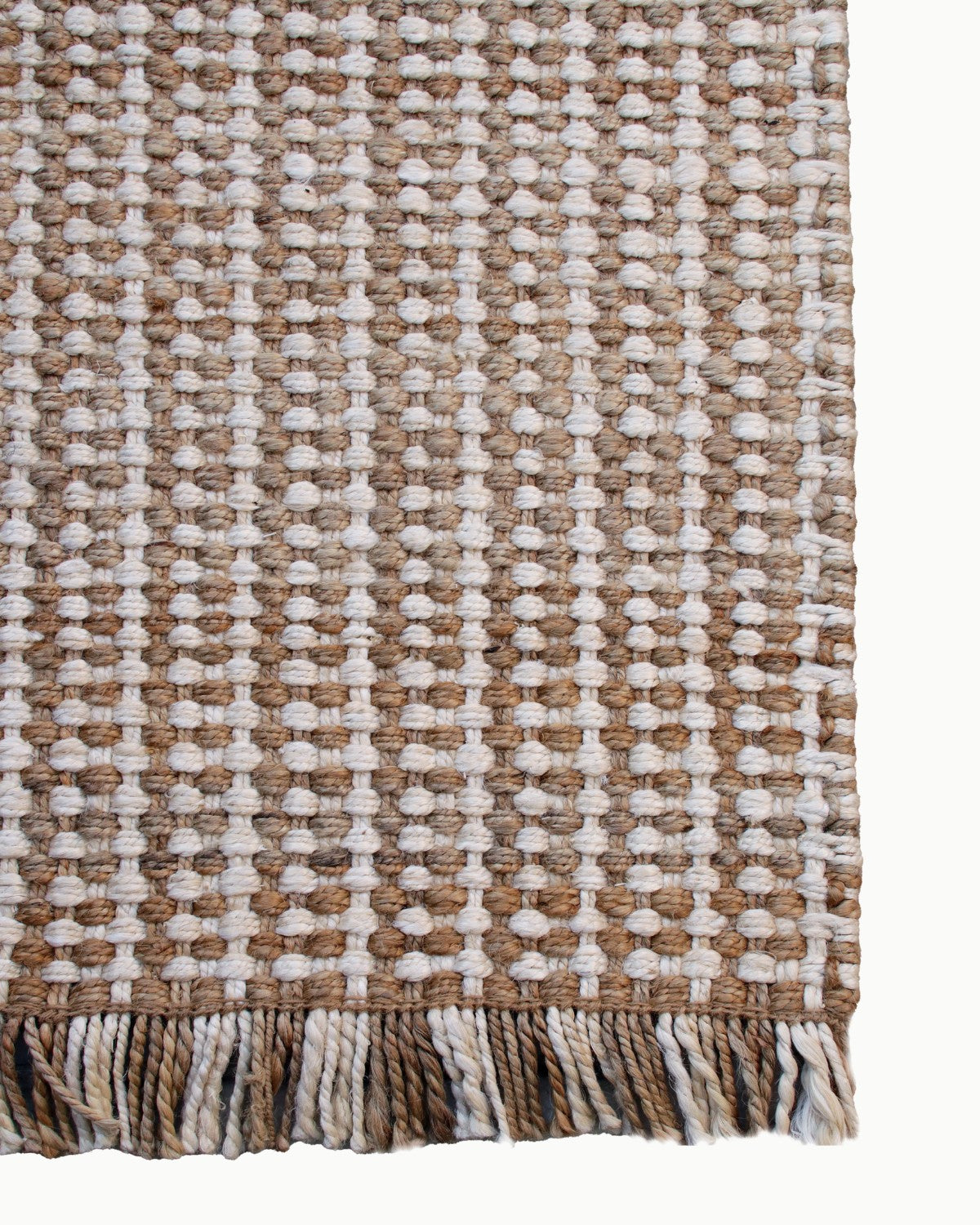 Lay-flat corner edge shot showing the artisan fringe. This heavy, durable profile grounds bedrooms with earthy warmth.