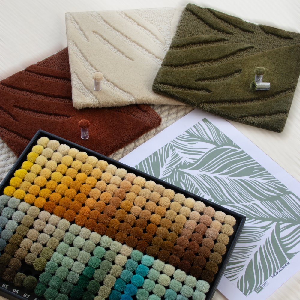 Custom rug design layup by House of Bohi, featuring hand-carved wool samples in ivory, rust and olive alongside a colour swatch tray and a sage green pattern CAD drawing.