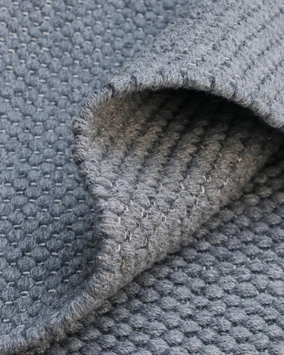Folded drape showcasing the soft texture of premium New Zealand wool and a low 12mm pile height.