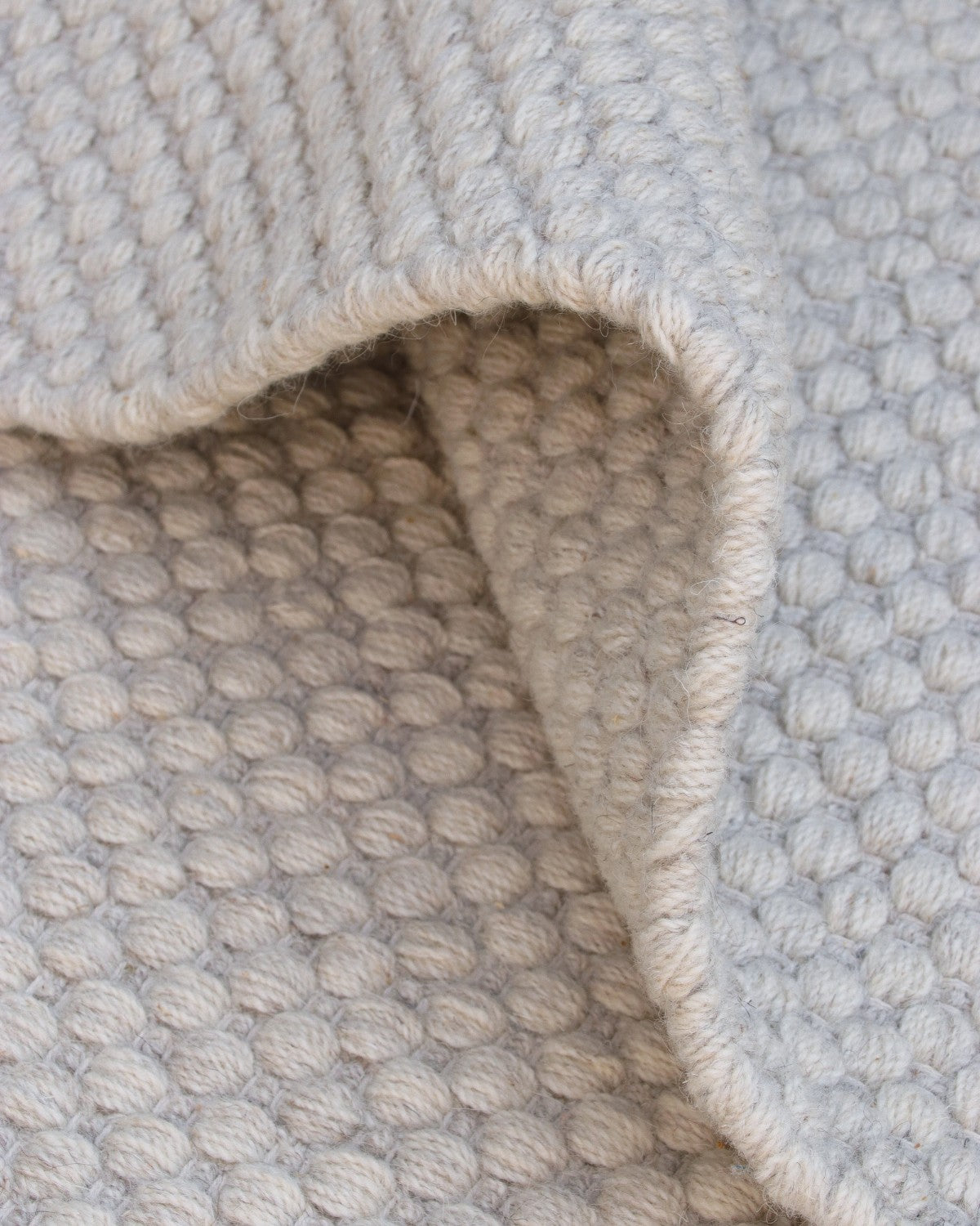 Folded drape showcasing the soft texture of premium New Zealand wool and a low 12mm pile height.
