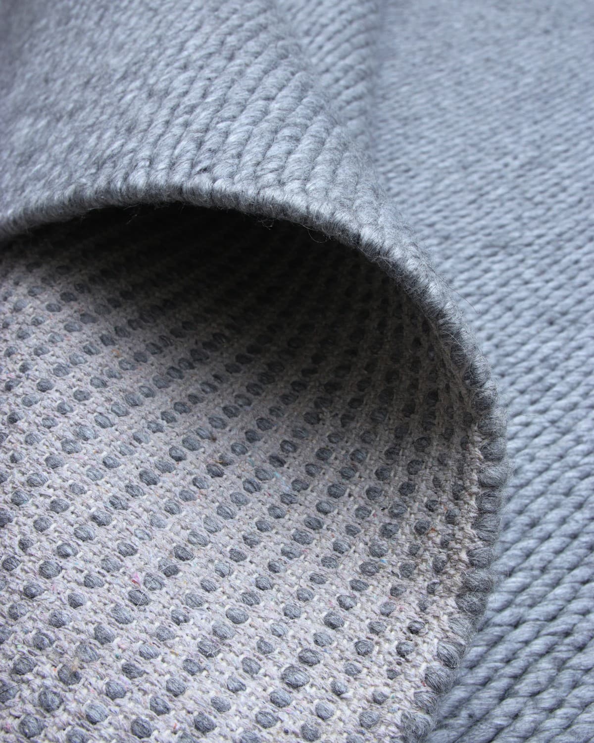 Folded corner highlighting the durable reversible edge. Ethically handmade in Bhadohi and GoodWeave certified for a bedroom.