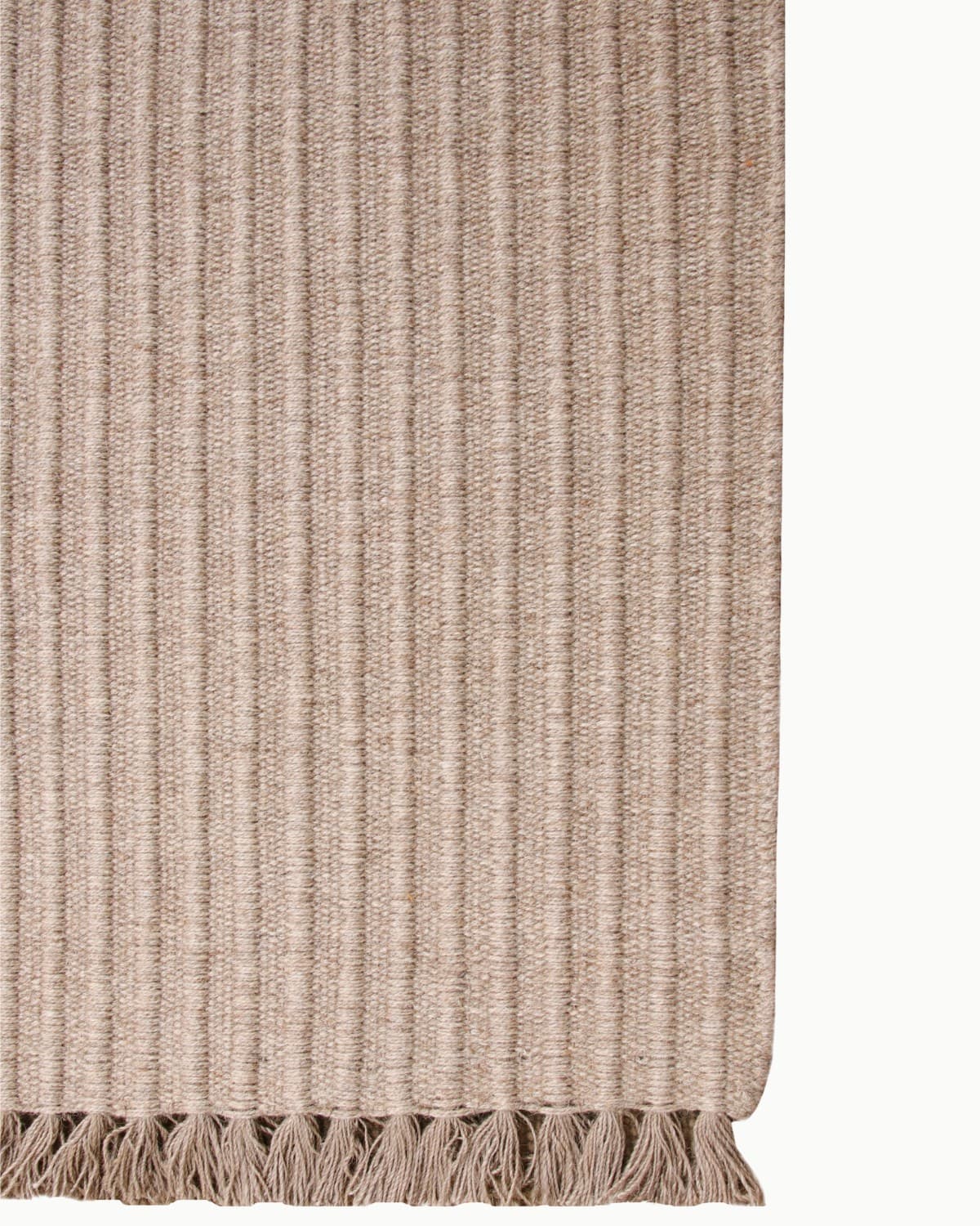 Playful fringe edge of a brown wool rug. Ethically handmade in Bhadohi, India and GoodWeave certified for a bedroom.