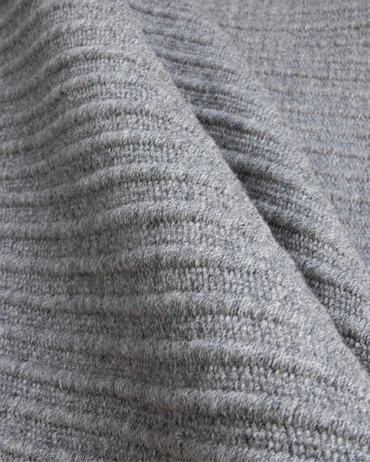 Folded reversible flatweave revealing subtle tactile relief and a 12mm pile height, ideal for a structured hallway.