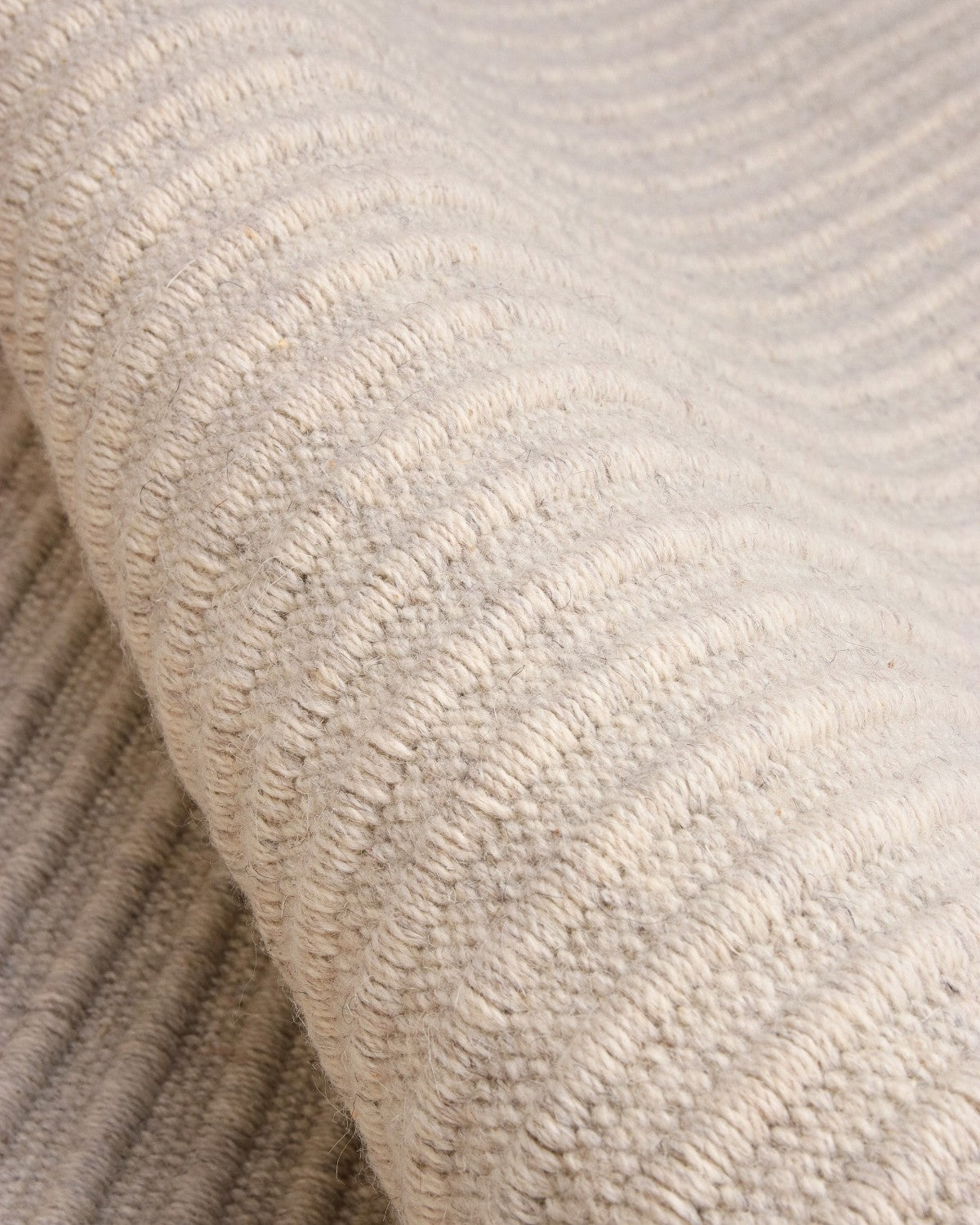 Close-up of a reversible flatweave showing a 12mm pile height, bringing structured calm to a living room.