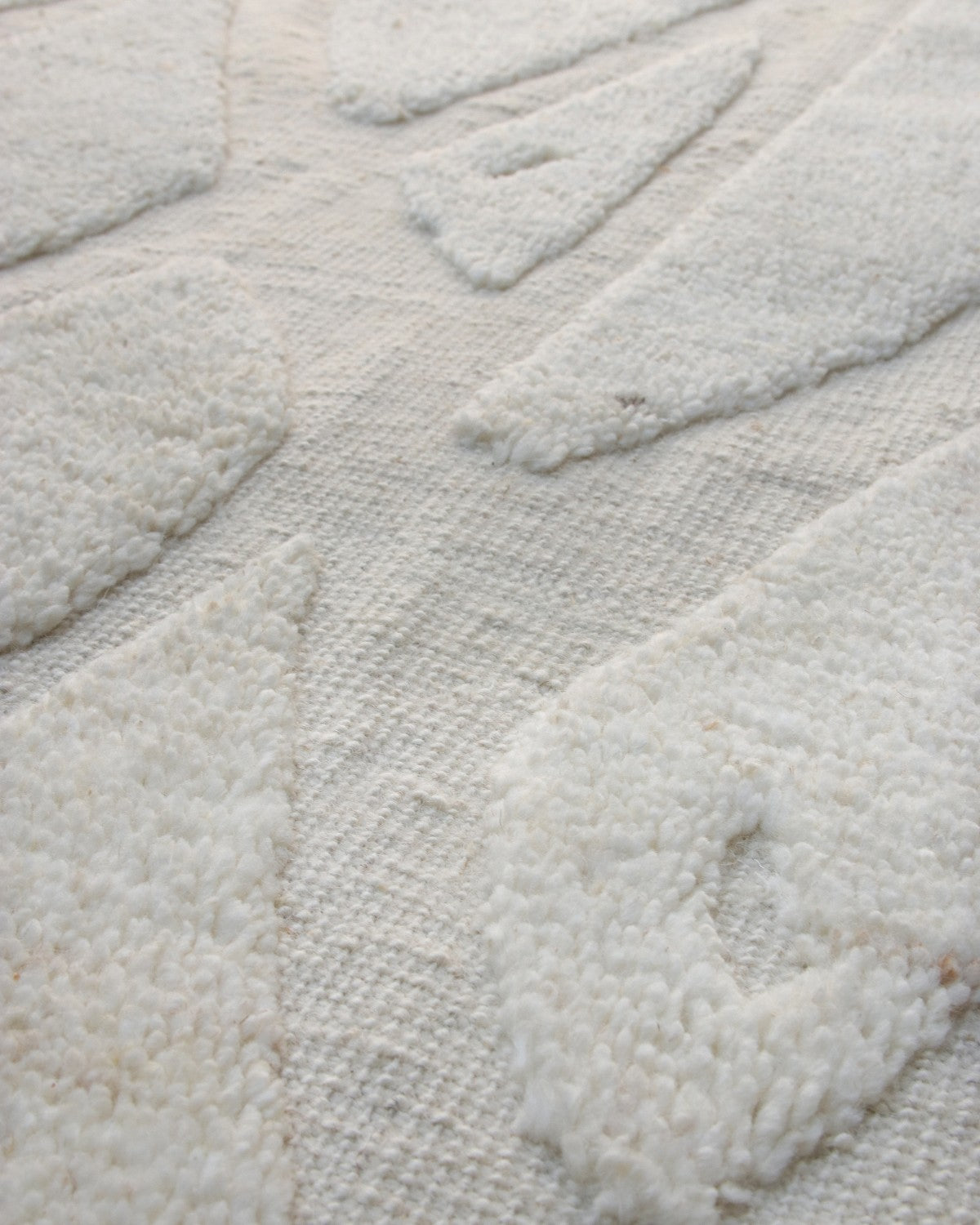 Textured organic geometry and an abstract diamond lattice inspired by tribal artefacts, crafted with modern restraint.