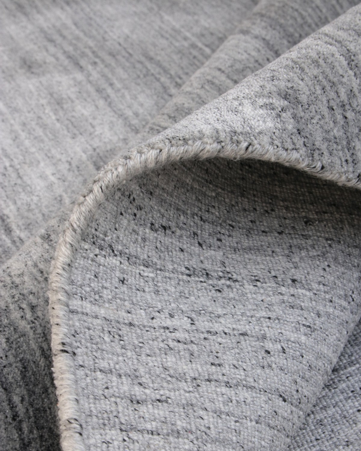 Folded handloomed fabric evoking wind-swept lines of a sand dune, fully GoodWeave certified for ethical production.