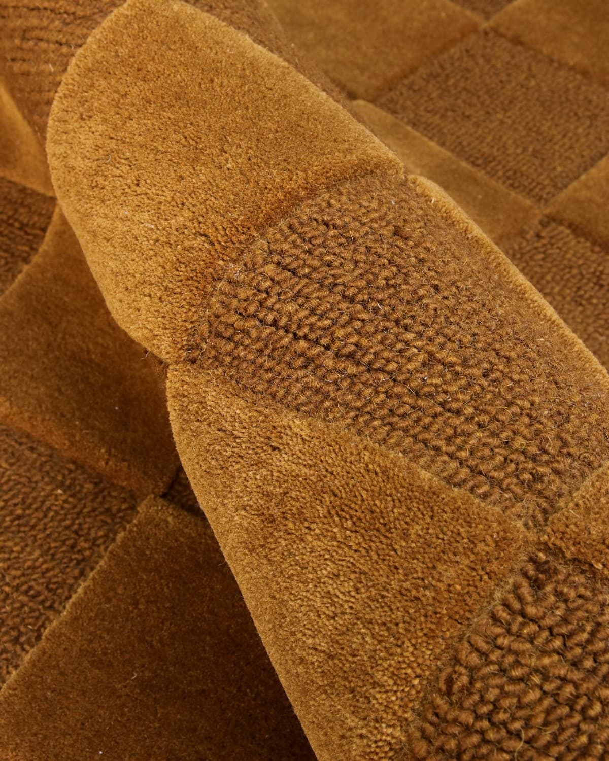 Alternating squares of plush 15mm cut pile and tight loop weave create a rhythmic interplay of depth and shadow.