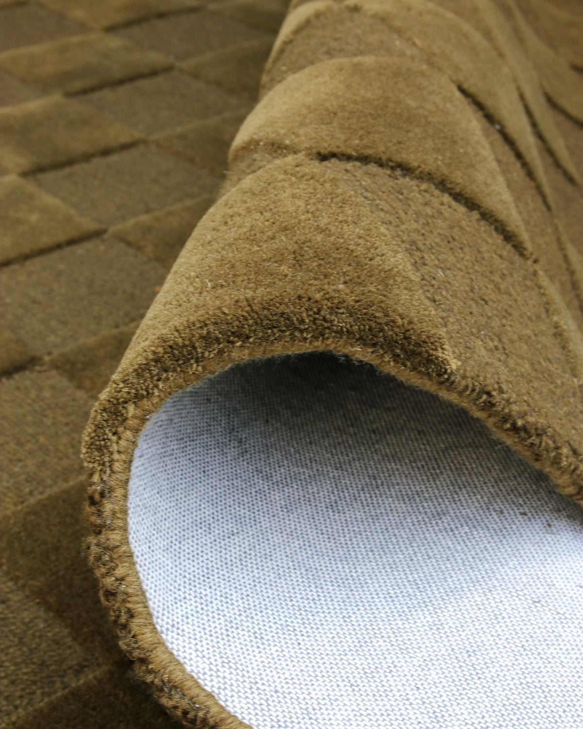 A folded corner reveals the durable backing and neat edge finishing of this GoodWeave Certified, ethically made rug.
