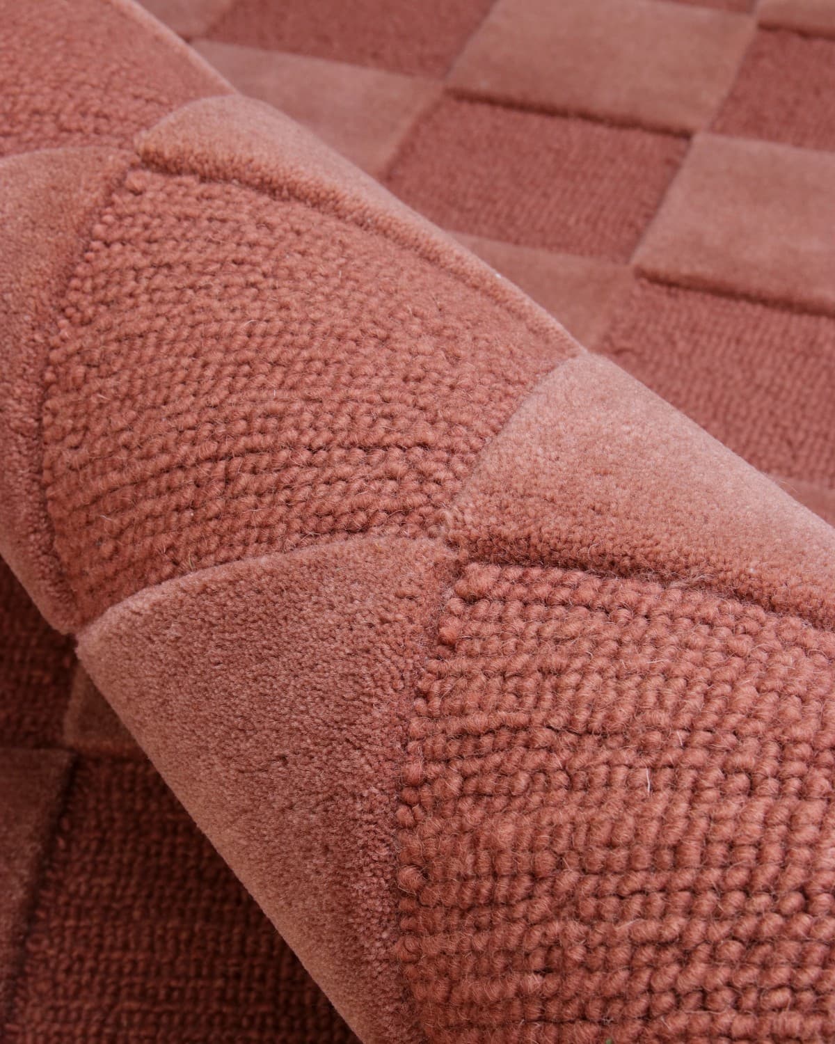 Alternating squares of plush 15mm cut pile and tight loop weave create a rhythmic interplay of depth and shadow.
