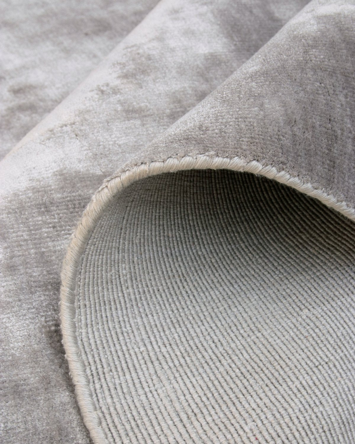 Folded corner revealing ethical GoodWeave certified handloom construction and secure edge binding from Bhadohi, India.