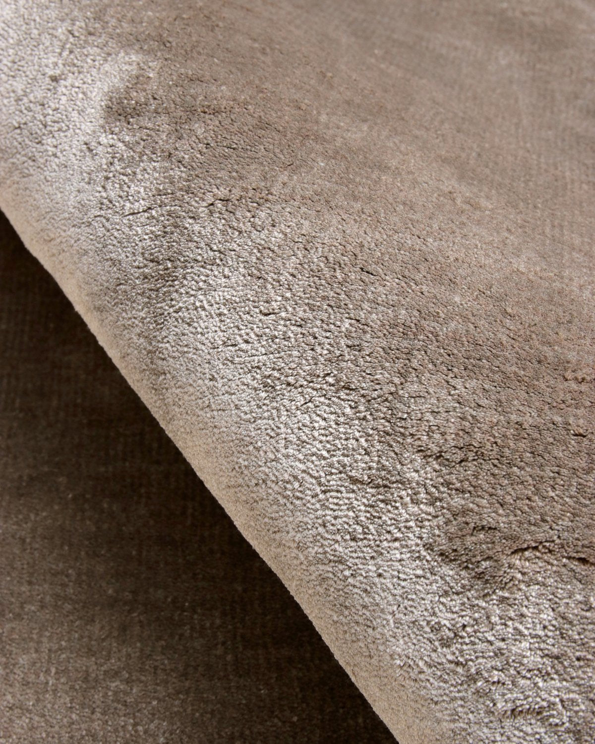 Close up of the handloomed surface, highlighting the smooth texture and rich, luminous color variations in the weave.