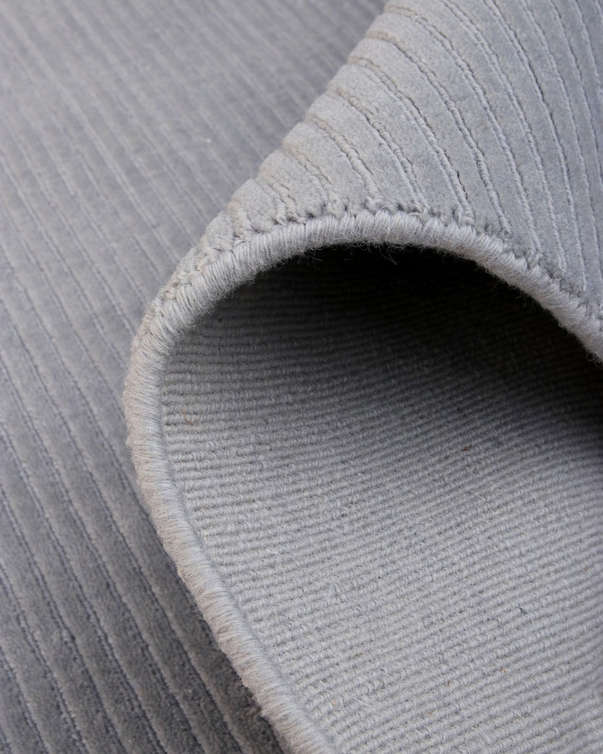 Folded silver grey piece highlighting crisp edge definition. This ethically produced GoodWeave certified design offers linear calm.