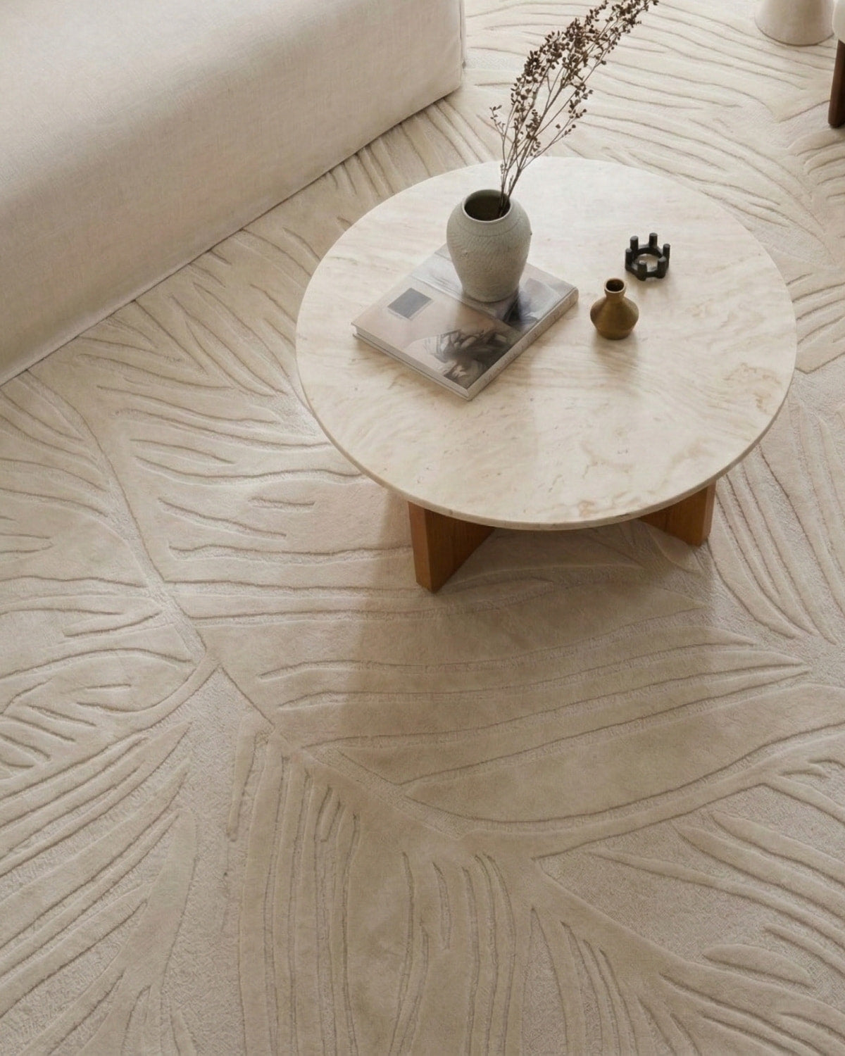 Sculptural field of loop and cut pile styled under a coffee table. It offers quiet precision for spaces valuing artistry.