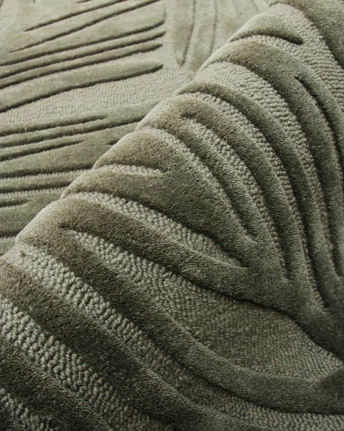 Close up of folded juniper cut and loop pile. The dense 15mm pile height catches light and shadow with quiet precision.
