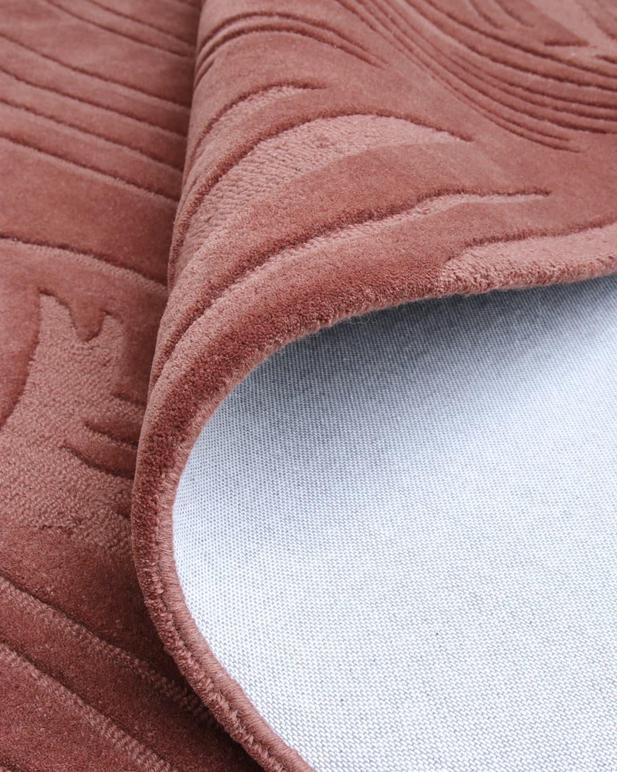 Rolled corner revealing edge finishing and backing. This GoodWeave certified piece brings quiet precision to bedrooms.