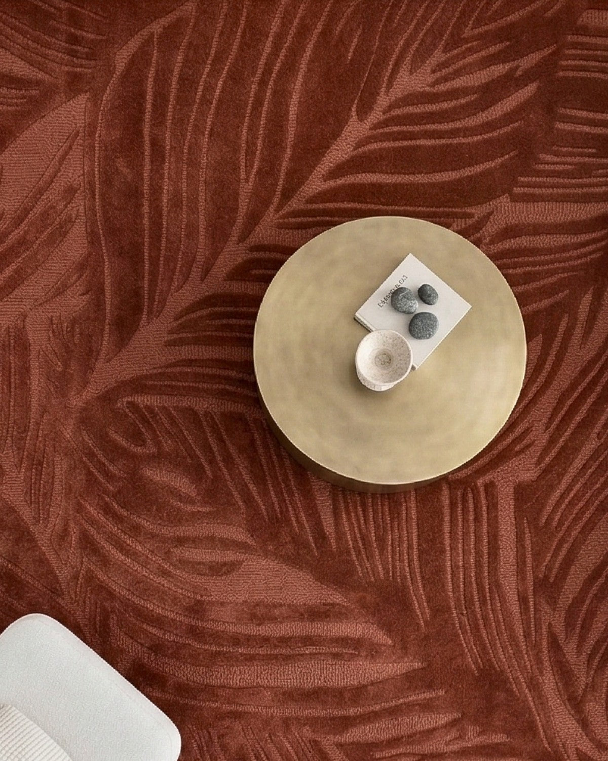 Overhead view of a styled coffee table over the rust leaf design. The tactile finish brings quiet precision to spaces.
