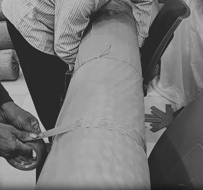 A finished handwoven rug is cleaned, rolled and hand-packed for transit from the House of Bohi workshop in Bhadohi, India.